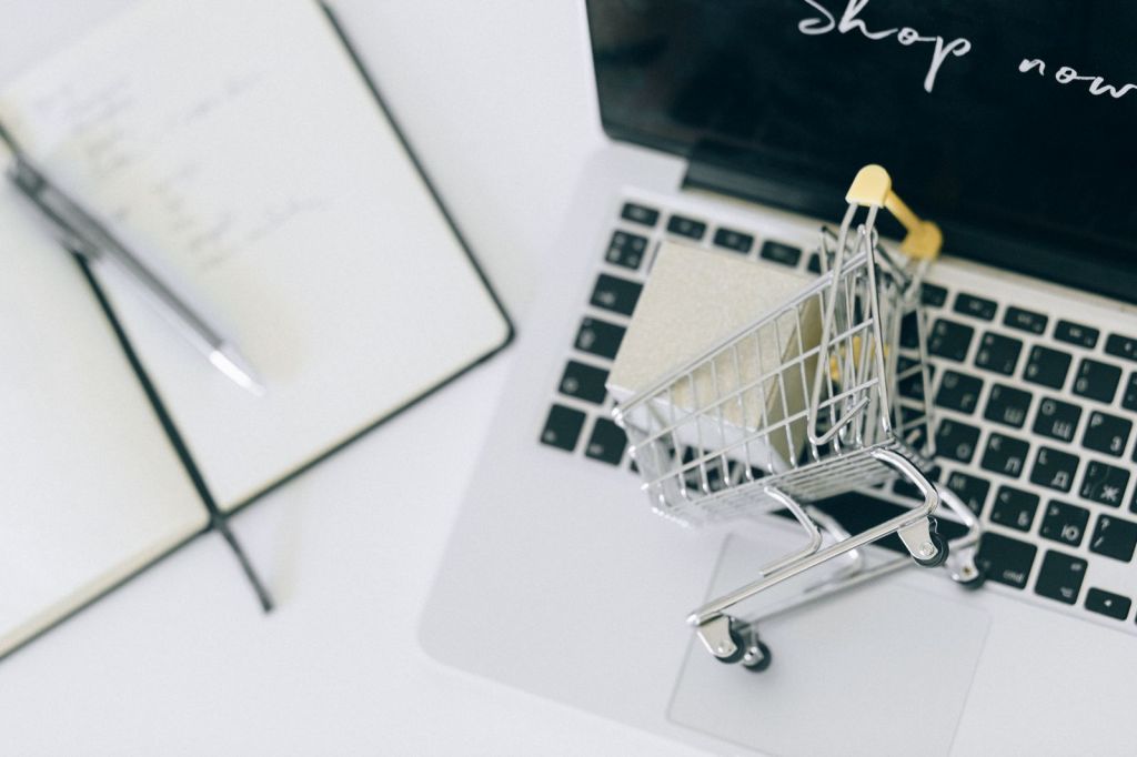 a miniature shopping cart on macbook laptop