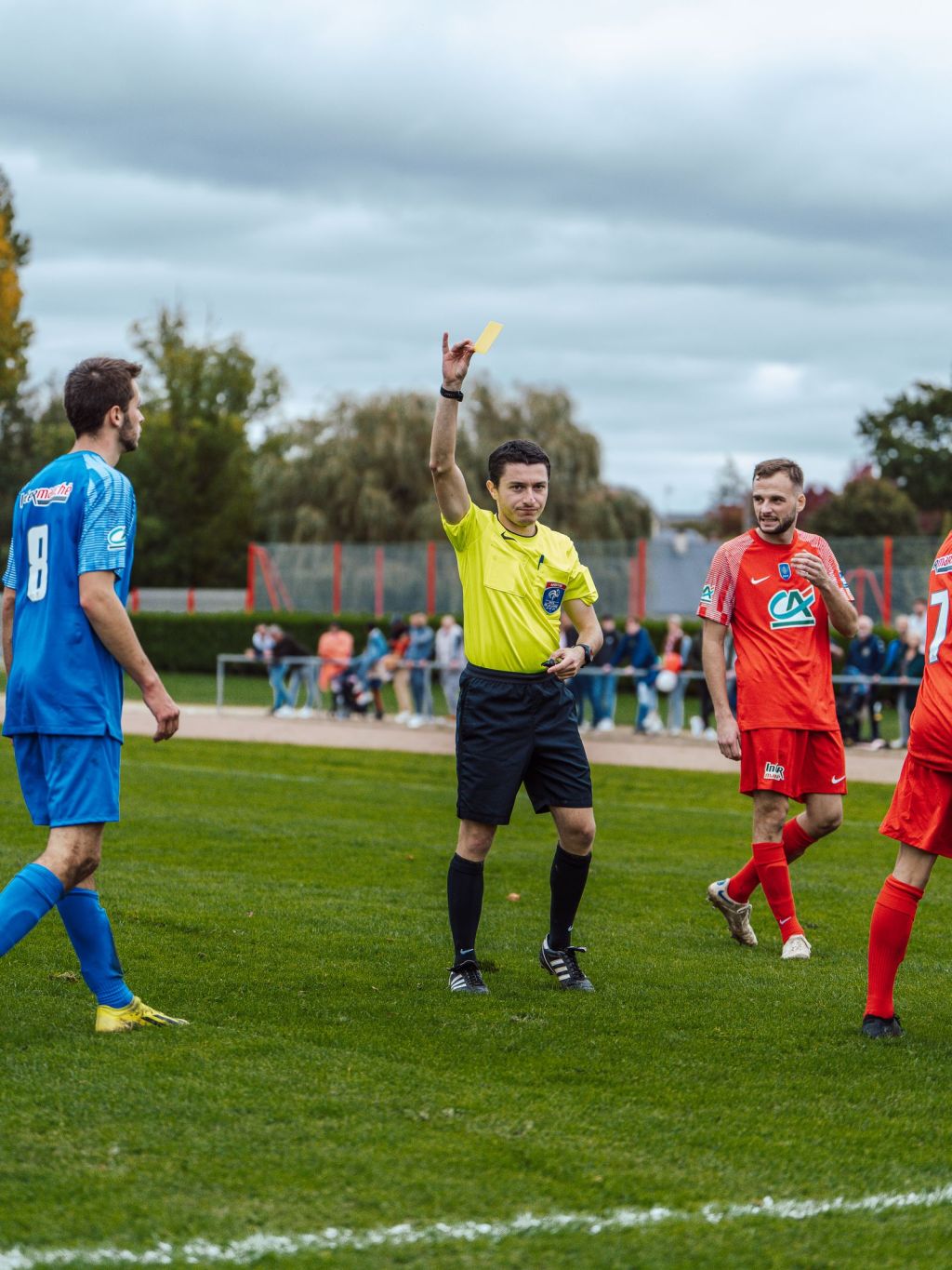 referee issuing yellow card during soccer game in france