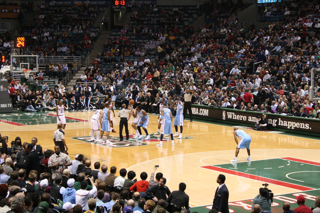 Players line up at center court for the opening tip-off in Milwaukee